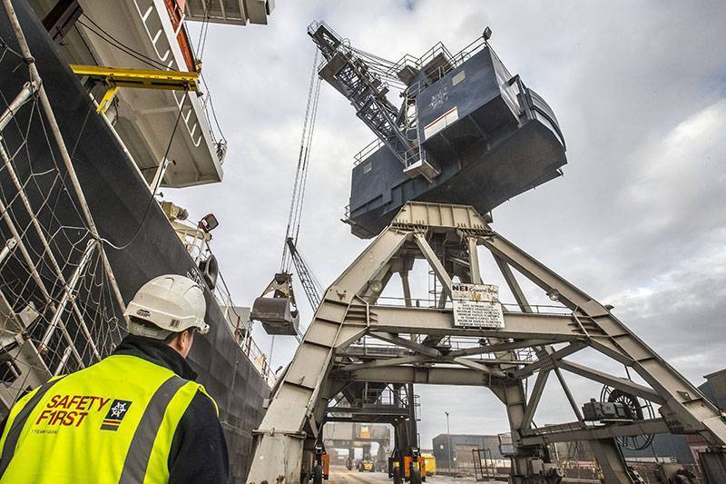 a port operator looking up at a crane at a Grain Terminal