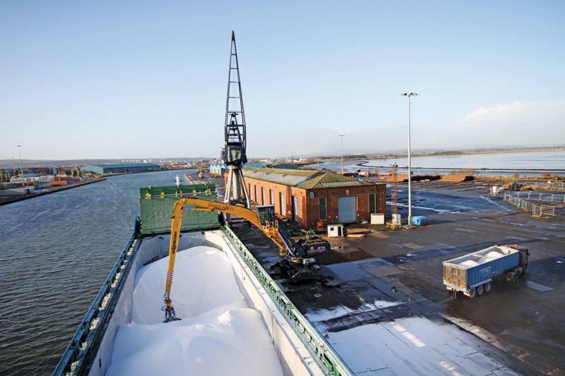 Crane discharging white powder/aggregates from bulk vessel at Forth Ports Grangemouth on North Wall