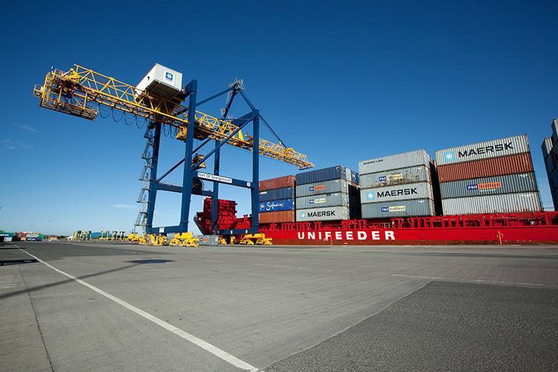 Gantry crane unloading containers from red Unifeeder vessel at Grangemouth, taken from quayside